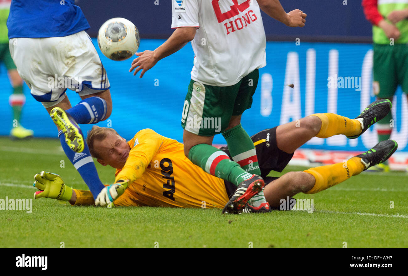 Gelsenkirchen, Germany. 05th Oct, 2013. Augsburg's goalkeeper Alexander Manninger (DOWN), Schalke's Adam Szalai (L) and Augsburg's Jeong-Ho Hong vie for the ball. Photo: Bernd Thissen (ATTENTION: Due to the accreditation guidelines, the DFL only permits the publication and utilisation of up to 15 pictures per match on the internet and in online media during the match.)/dpa/Alamy Live News Stock Photo