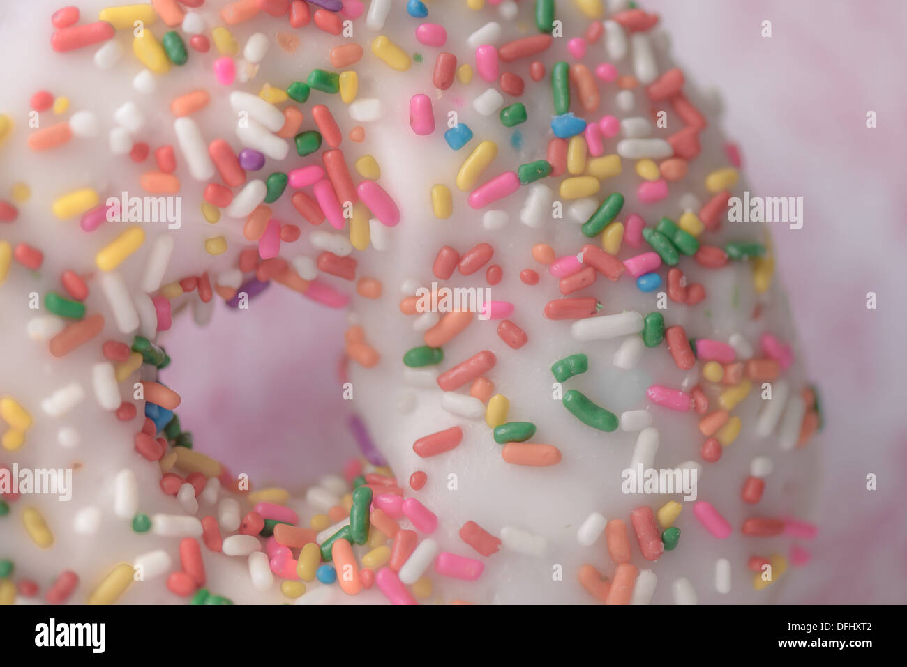 Frosted donut with colored sprinkles Stock Photo