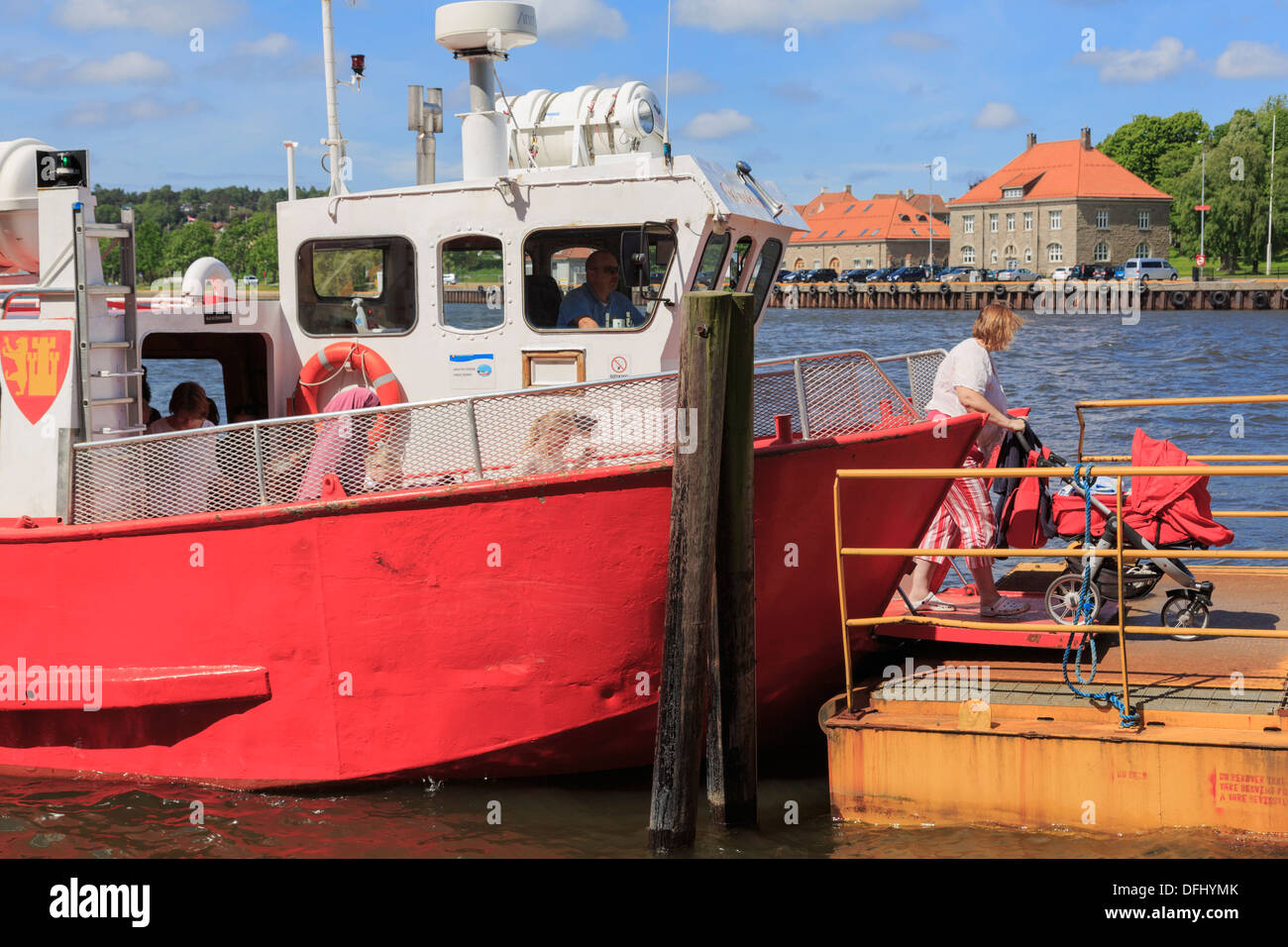 Woman passenger with pushchair disembarking from free ferry boat service across River Glomma to old Gamlebyen Fredrikstad Norway Stock Photo