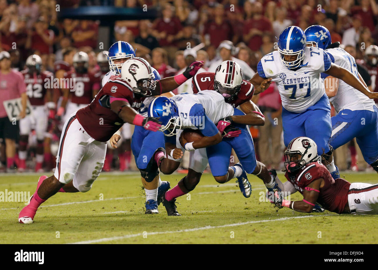 Columbia, SC, USA. 5th Oct, 2013. UK's Jalen Whitlow was sacked by South Carolina's 97- J.T. Surratt and 5- Darius English as the University of Kentucky played South Carolina in Williams-Brice Stadium in Columbia, S.C. Saturday, October 5, 2013. This is first quarter football action. Photo by Charles Bertram | Staff Credit:  Lexington Herald-Leader/ZUMAPRESS.com/Alamy Live News Stock Photo