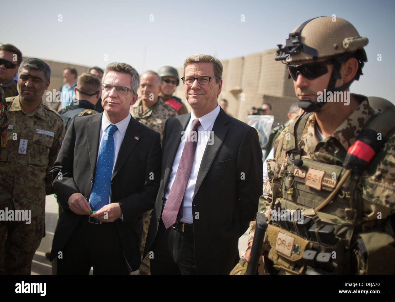 Kunduz, Afghanistan. 06th Oct, 2013. German Foreign Minister Guido Westerwelle (C) and Defence Minister Thomas de Maiziere (L) stand next to a soldier as they attend the ceremonies prior to the handing over of the field camp of the German ISAF troops in Kunduz, Afghanistan, 06 October 2013. Soldiers of the German contingency of the International Security Assistance Force (ISAF) on 06 October finally withdrew from their base in Kunduz which from now on will be used by the Afghan National Army (ANA) and the ANCOP. Photo: MICHAEL KAPPELER/dpa/Alamy Live News Stock Photo