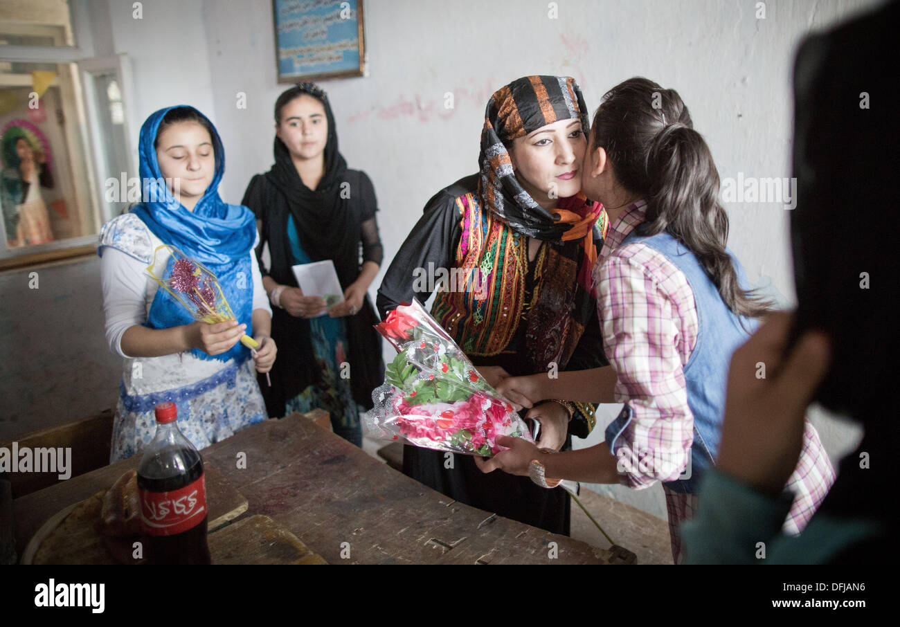 Kunduz, Afghanistan. 05th Oct, 2013. Schamim Sial, teacher and director of the Fatima Tushara Girls School poses with pupils in Kunduz, Afghanistan, 05 October 2013. The girls celebrate the 'Teachers Day' in which all students bring gifts and food and celebrate throughout the school. Soldiers of the German contingency of the International Security Assistance Force (ISAF) on 06 October finally withdrew from their base in Kunduz which from now on will be used by the Afghan National Army (ANA) and the ANCOP. Photo: MICHAEL KAPPELER/dpa/Alamy Live News Stock Photo