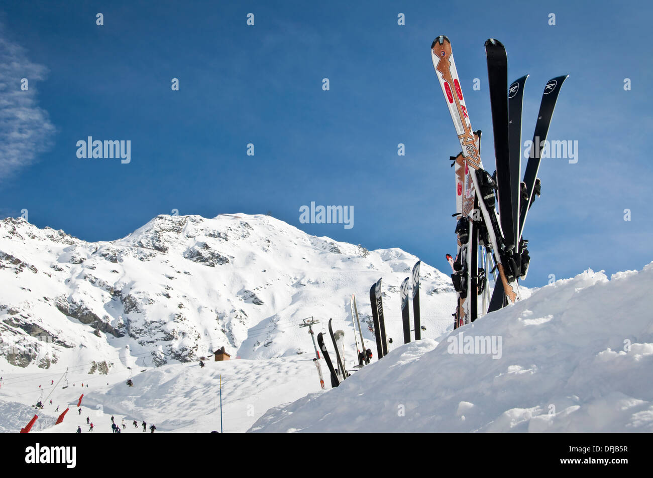 Skis standing in the snow, mountain background Stock Photo