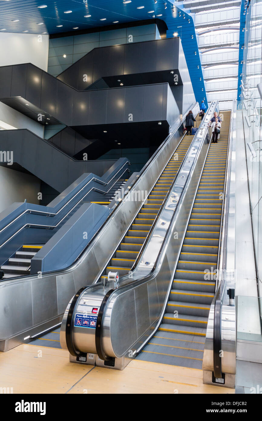 Passengers on escalators at the rear entrance to the redeveloped railway train station at Reading, Berkshire, England, GB, UK. Stock Photo