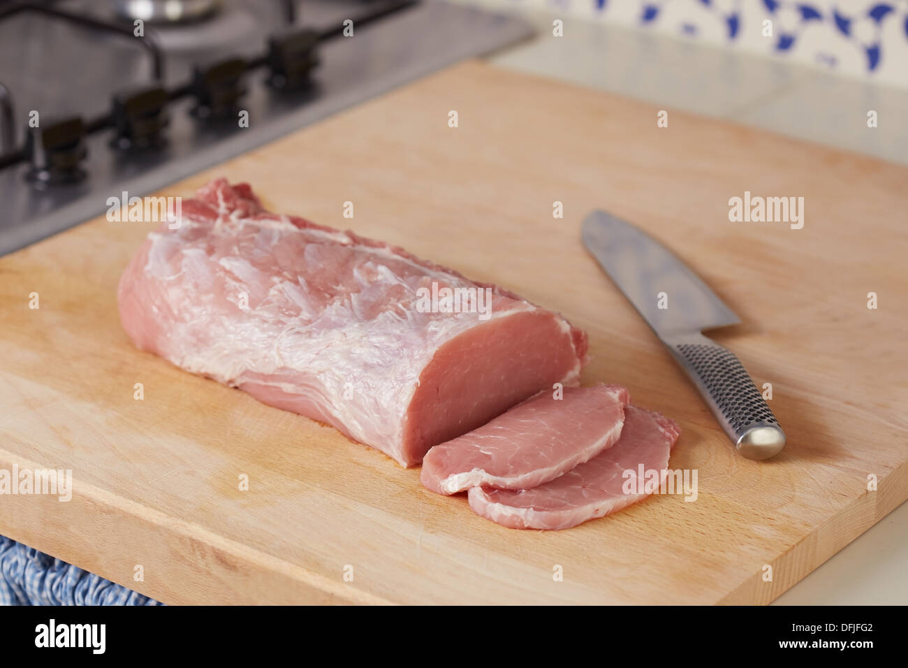 Cutting whole raw pork loin at home Stock Photo