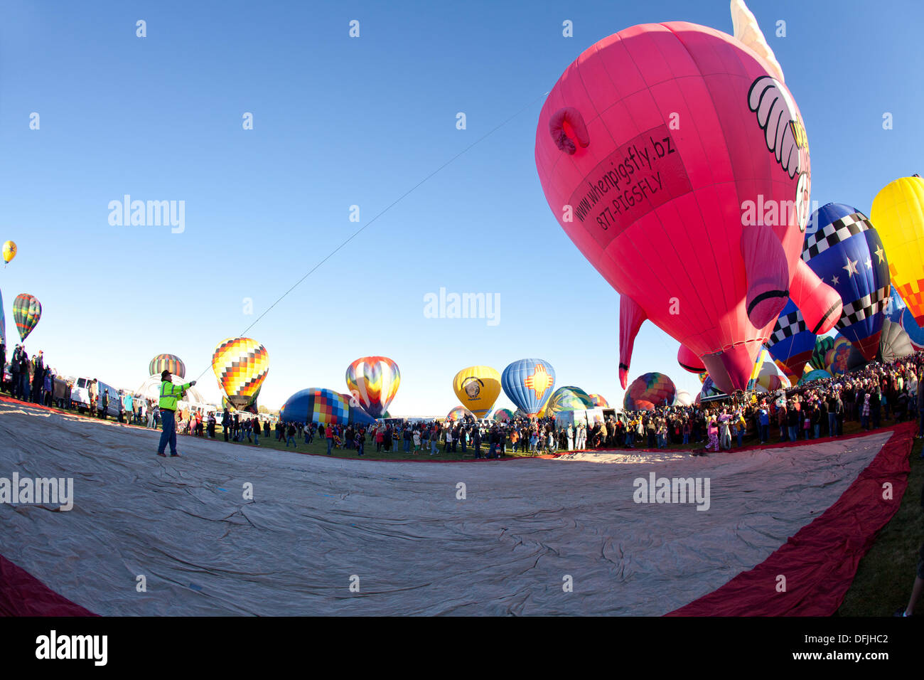 Albuquerque, NM, USA. 5th Oct, 2013. . Man pulls rope to steady a pink hot air balloon, First day of mass ascension at Albuquerque International Balloon Fiesta on Saturday October 5, 2013. Albuquerque, New Mexico, USA. Credit:  Christina Kennedy/Alamy Live News Stock Photo