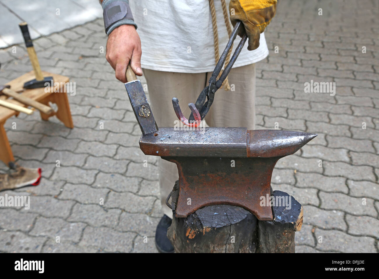Blacksmith forges a horseshoe, on the anvil Stock Photo