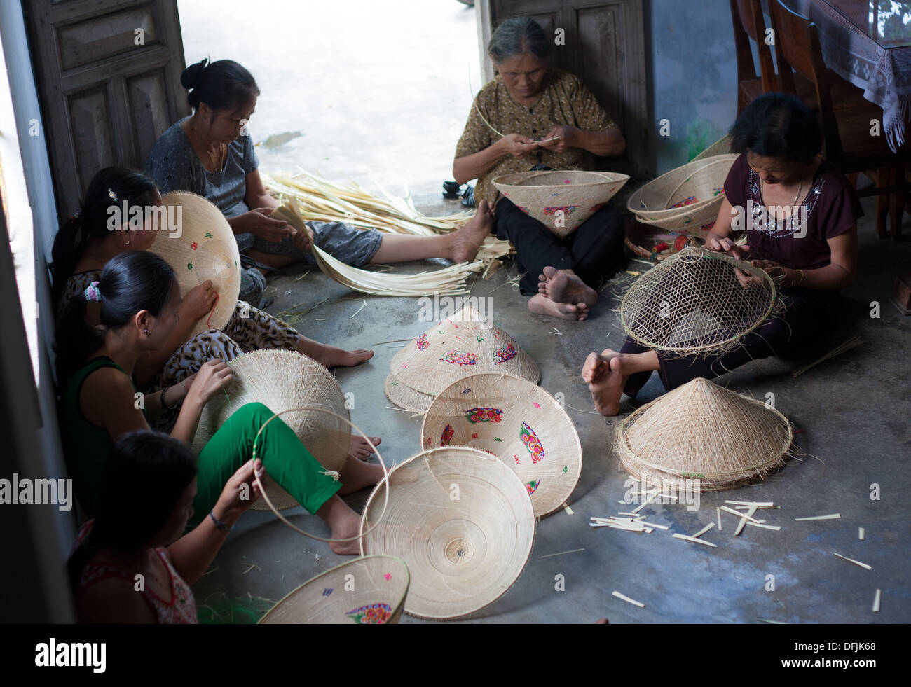 Group of Vietnamese woman working as handicraftsman to make conical straw hat at trade village, Vietnam Stock Photo