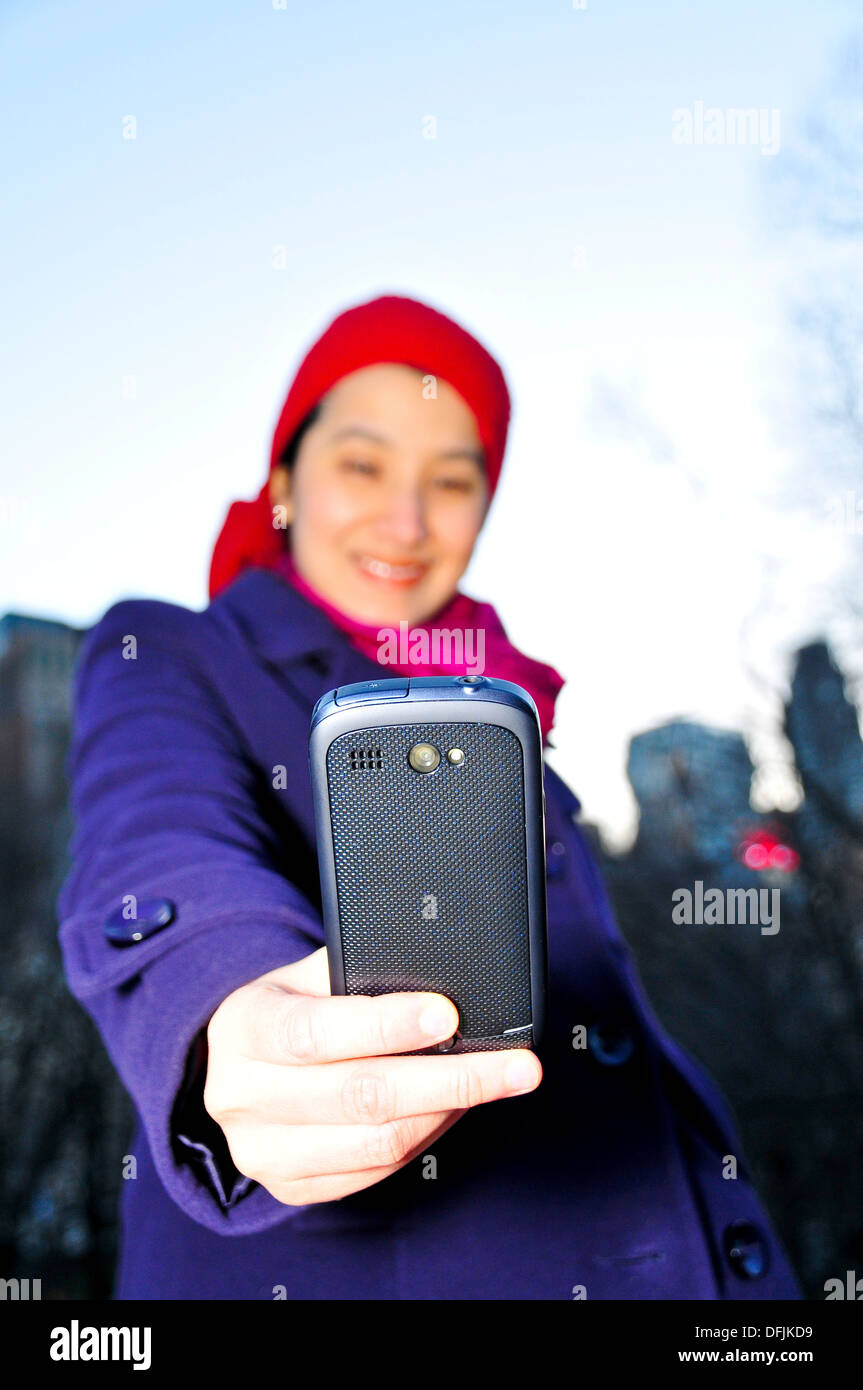 Pretty Latino woman using smart phone in Central Park, New York City, USA Stock Photo