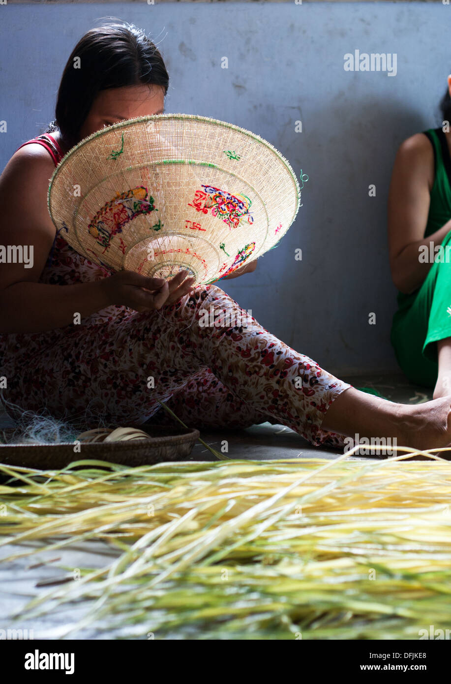 People make conical straw hat at trade village Stock Photo
