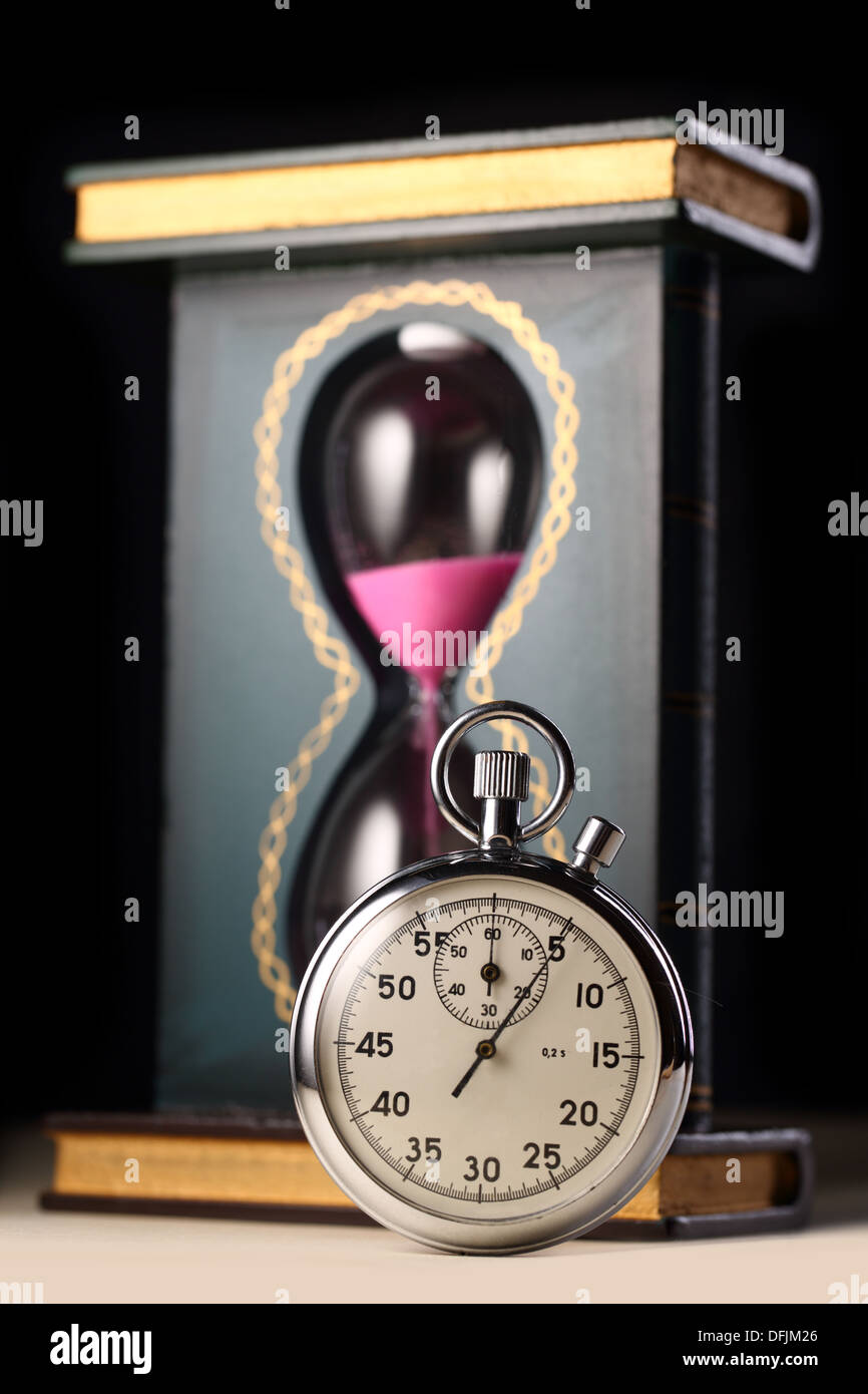 Stopwatch and sand glass on black background Stock Photo