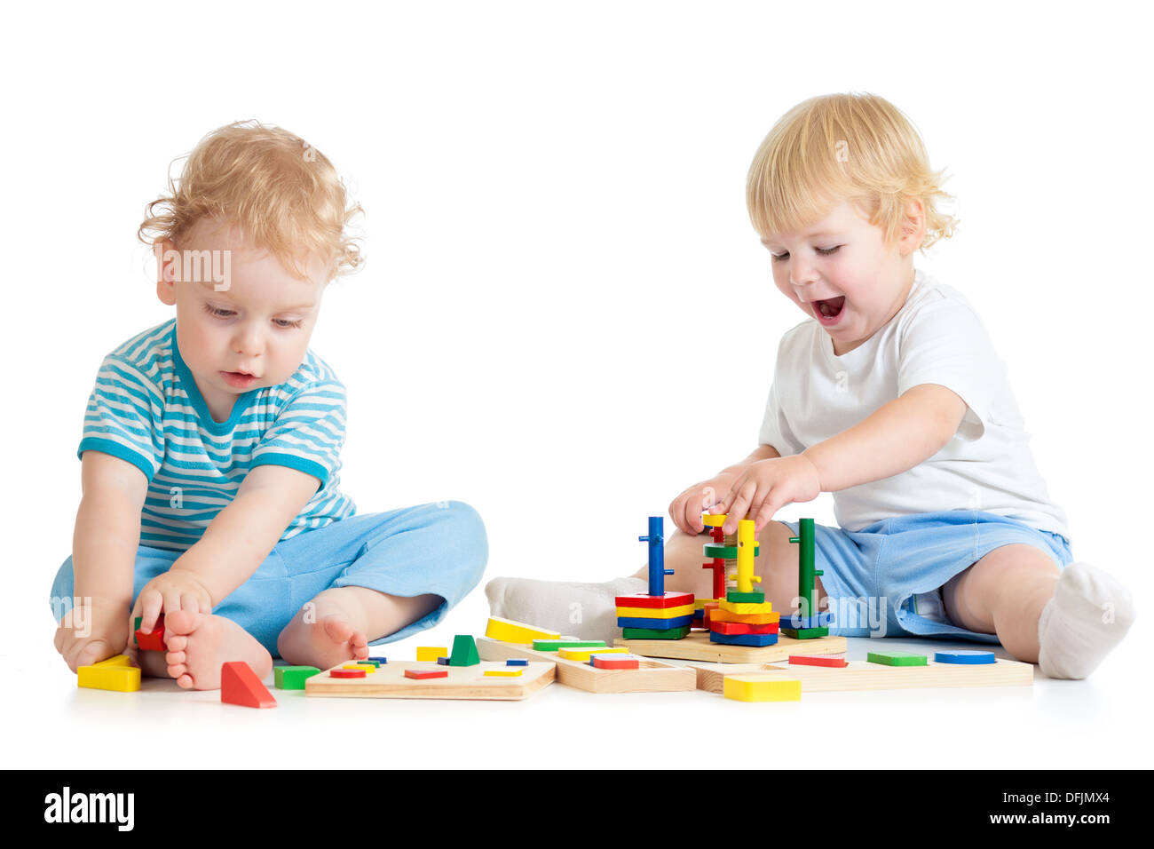 Concentrated child playing logical education toys with great interest on white background Stock Photo