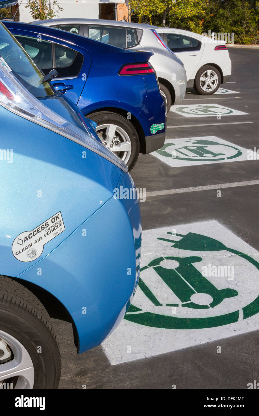 EV symbol painted on parking spaces at a company parking lot indicating spots are reserved for plug-in electric cars Stock Photo