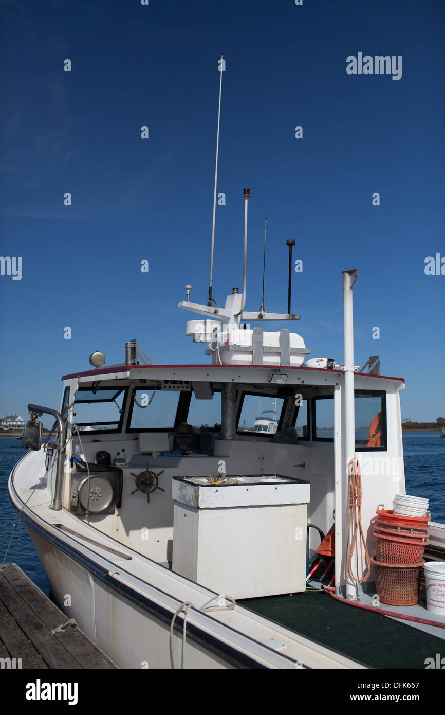 Lobster boat alongside a lobster dock in Maine getting ready to buy and
