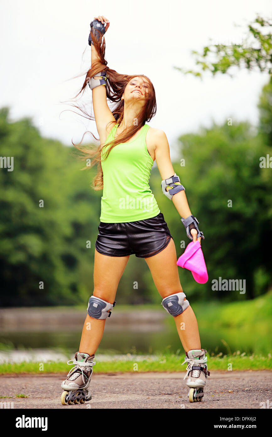 Happy young girl enjoying roller skating rollerblading on inline skates  sport in park. Woman in outdoor activities Stock Photo - Alamy