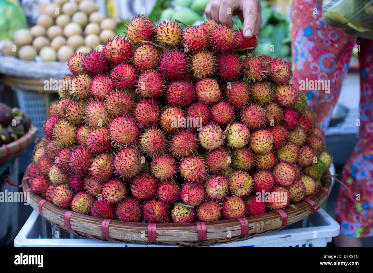 Basket of rambutan fruit for sale at market in Saigon, Vietnam. Stock Photo