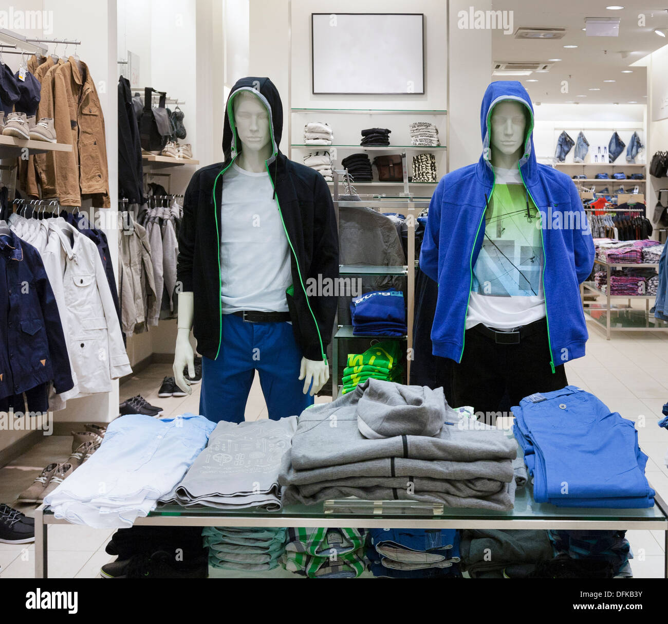 Shop interior with mannequin, dummy. Folded clothing on rack. Fashion