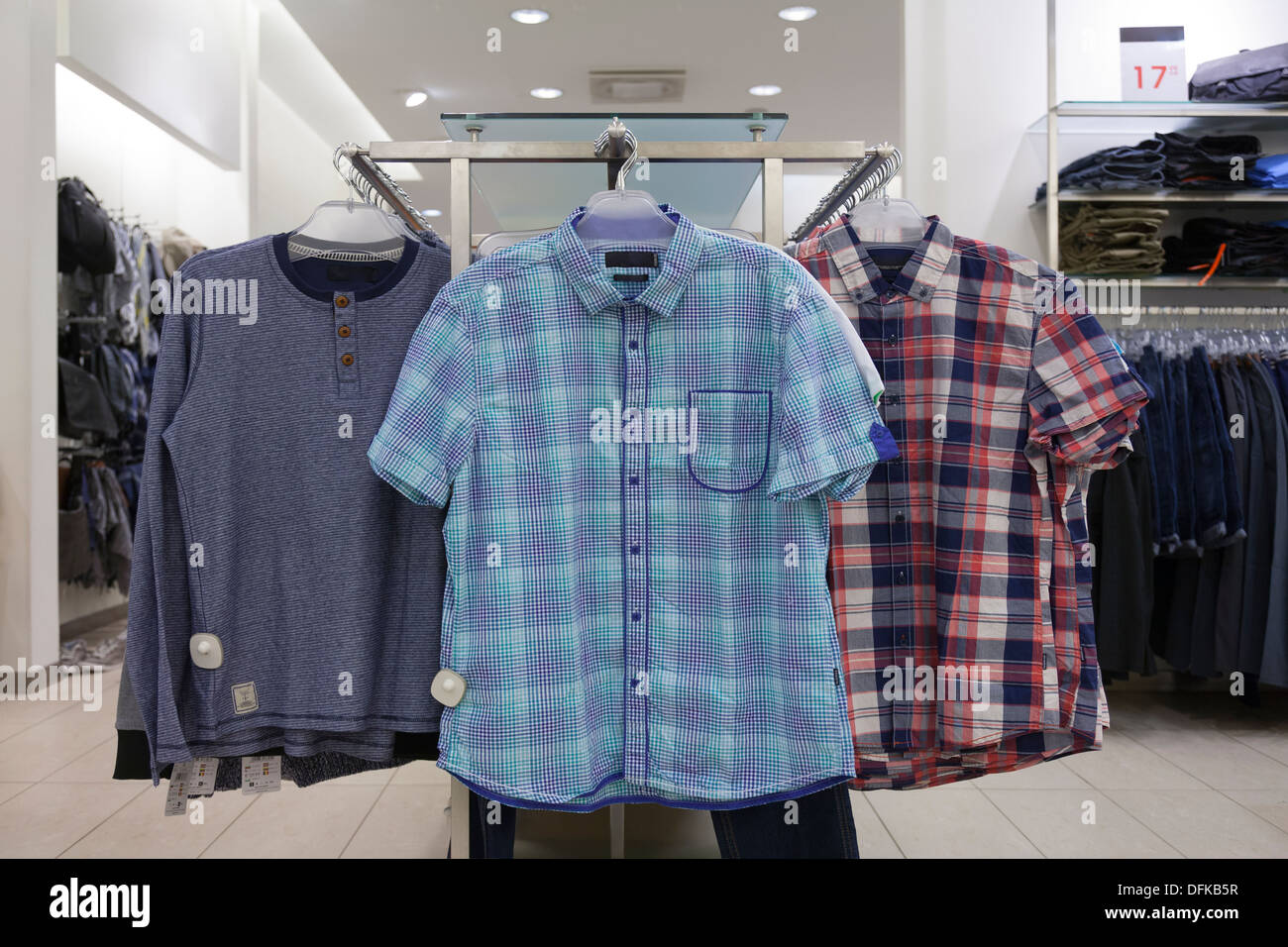 Close-up of blouses, shirts hanging on rack in retail shop. Store interior. Stock Photo