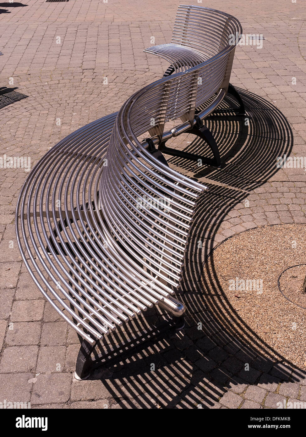 S shaped curved stainless steel metal bench seat, Loughborough, Leicestershire, England UK Stock Photo
