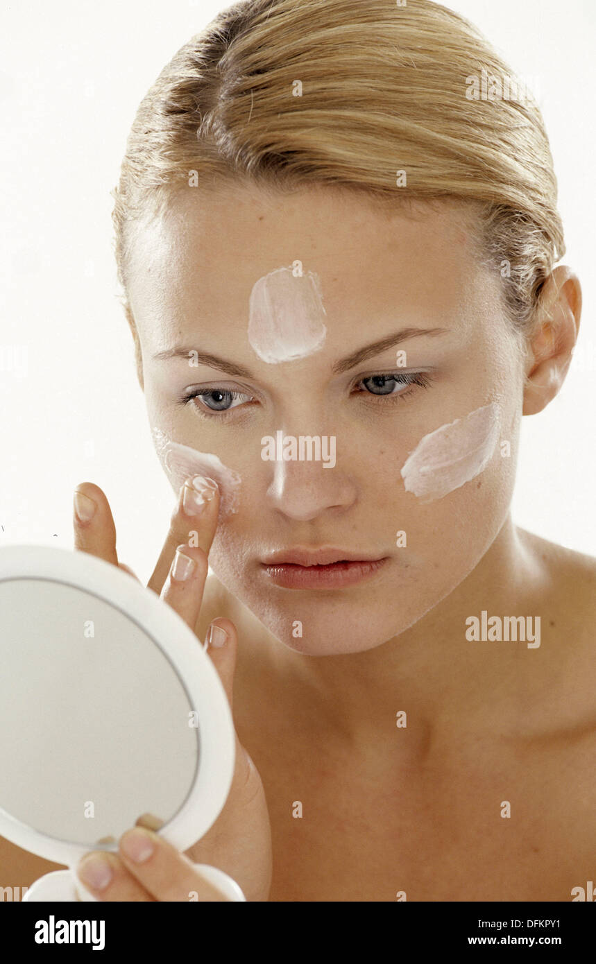 Woman applying facial cream Stock Photo Alamy