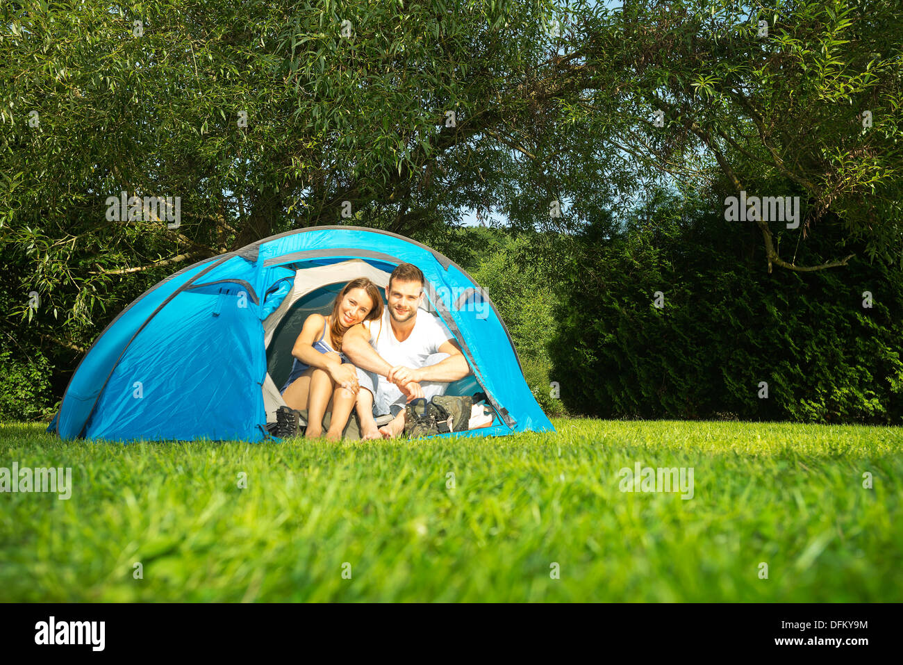 Portrait of a young couple sitting in a tent Stock Photo