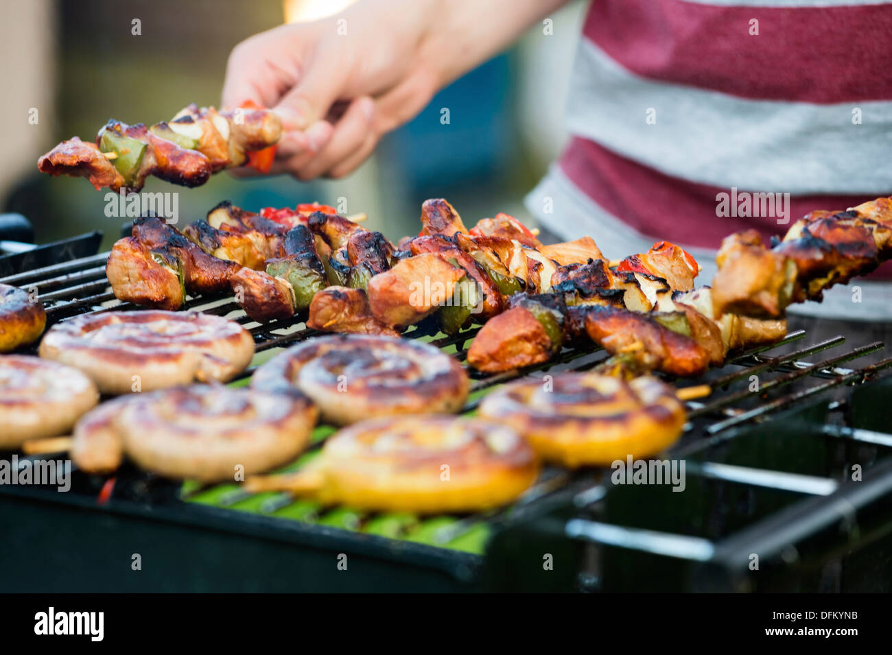 Midsection of man barbecuing at garden party Stock Photo
