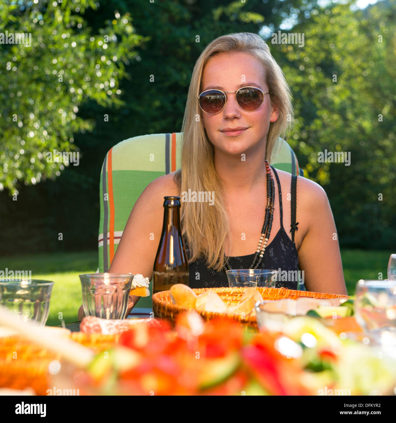 A young woman enjoying a garden party on a sunny afternoon Stock Photo