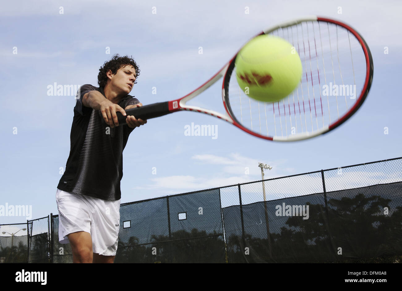 Tennis player hitting with a giantsized racket Stock Photo Alamy