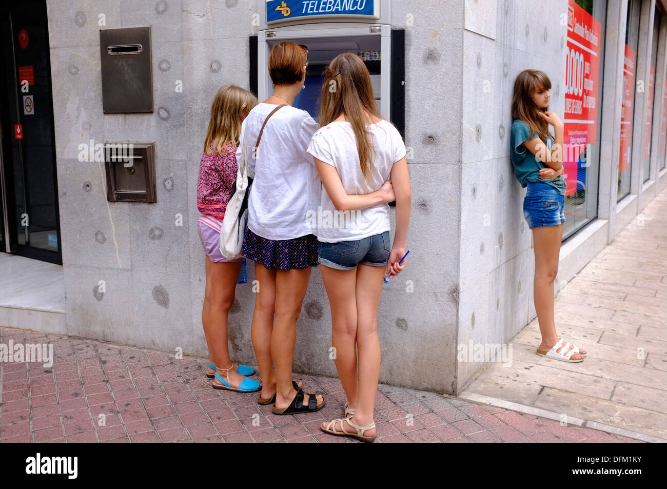 Mother at cashpoint with daughters, Majorca, Balearic Islands Stock Photo