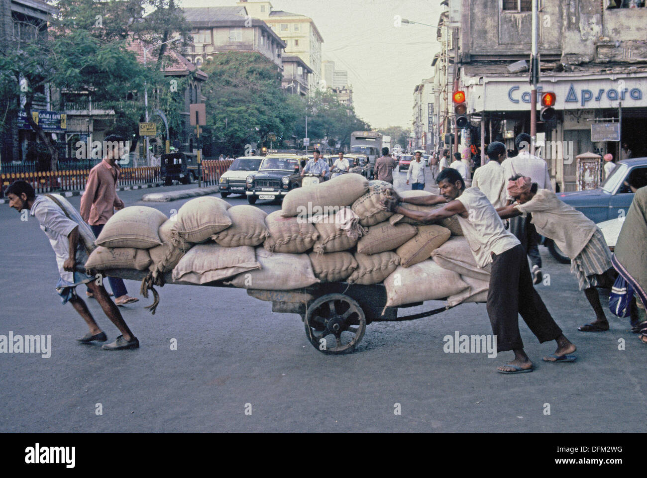 Men in Bombay/Mumbai push a heavy load Stock Photo