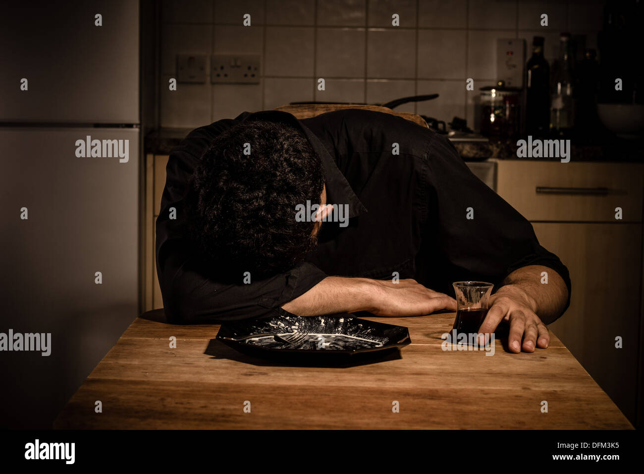 Sad young man having dinner by himself Stock Photo