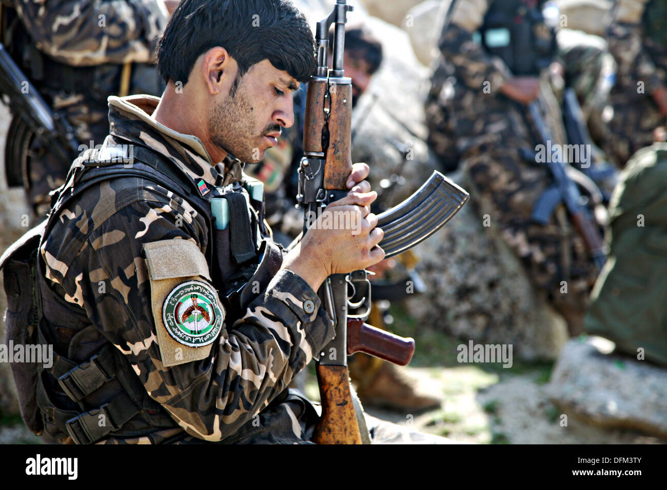 An Afghan National Directorate of Security soldier examines his Stock