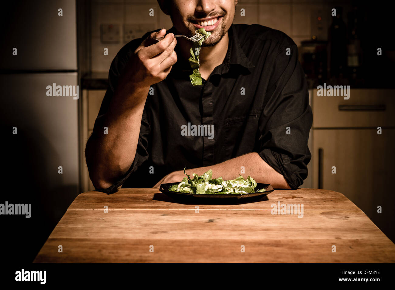 Happy young man having dinner at home Stock Photo - Alamy