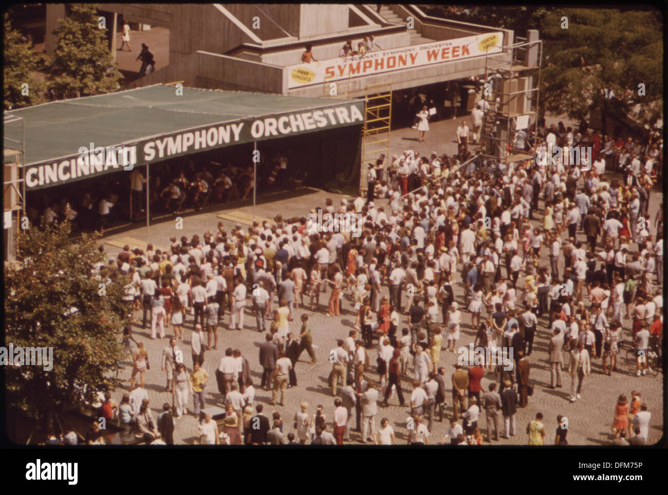 A photograph capturing a noon concert by the Cincinnati Symphony Orchestra at Fountain Square, an annual summer event. The orchestra performs in the open air, bringing classical music to the public. Stock Photo