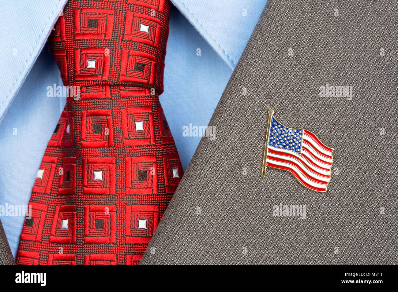 An American flag lapel pin on the collar of a business suit jacket shows patriotism Stock Photo