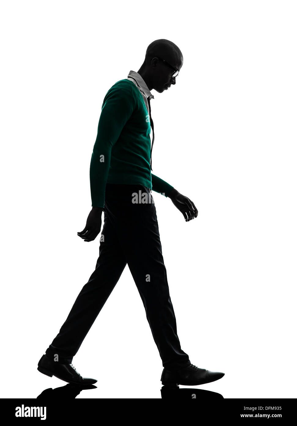 one african black man walking looking down sad in silhouette studio on