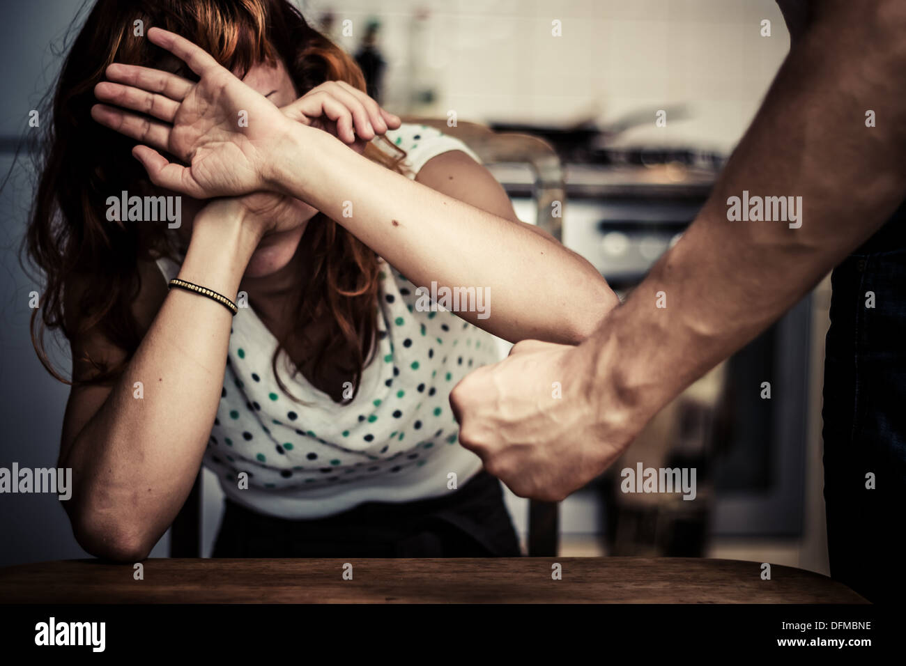 Young woman covering her face in fear of domestic violence Stock Photo