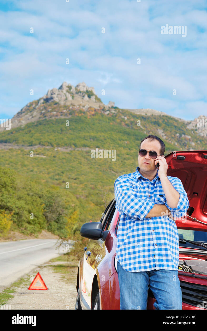 Adult man is calling to support standing beside broken car Stock Photo