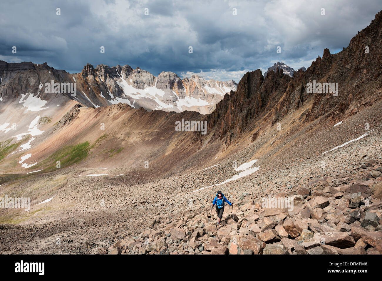 Female hiker ascending the rocky south slopes of Lavender Col route on Mt. Sneffels (14150 ft), San Juan mountains, Colorado, US Stock Photo