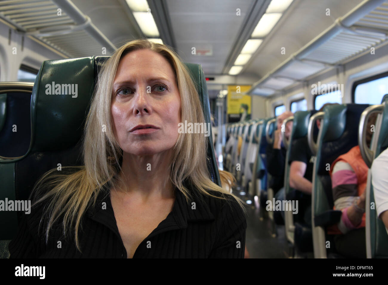 Woman daydreaming on a commuter train from the suburbs into New York City, New York, USA Stock Photo
