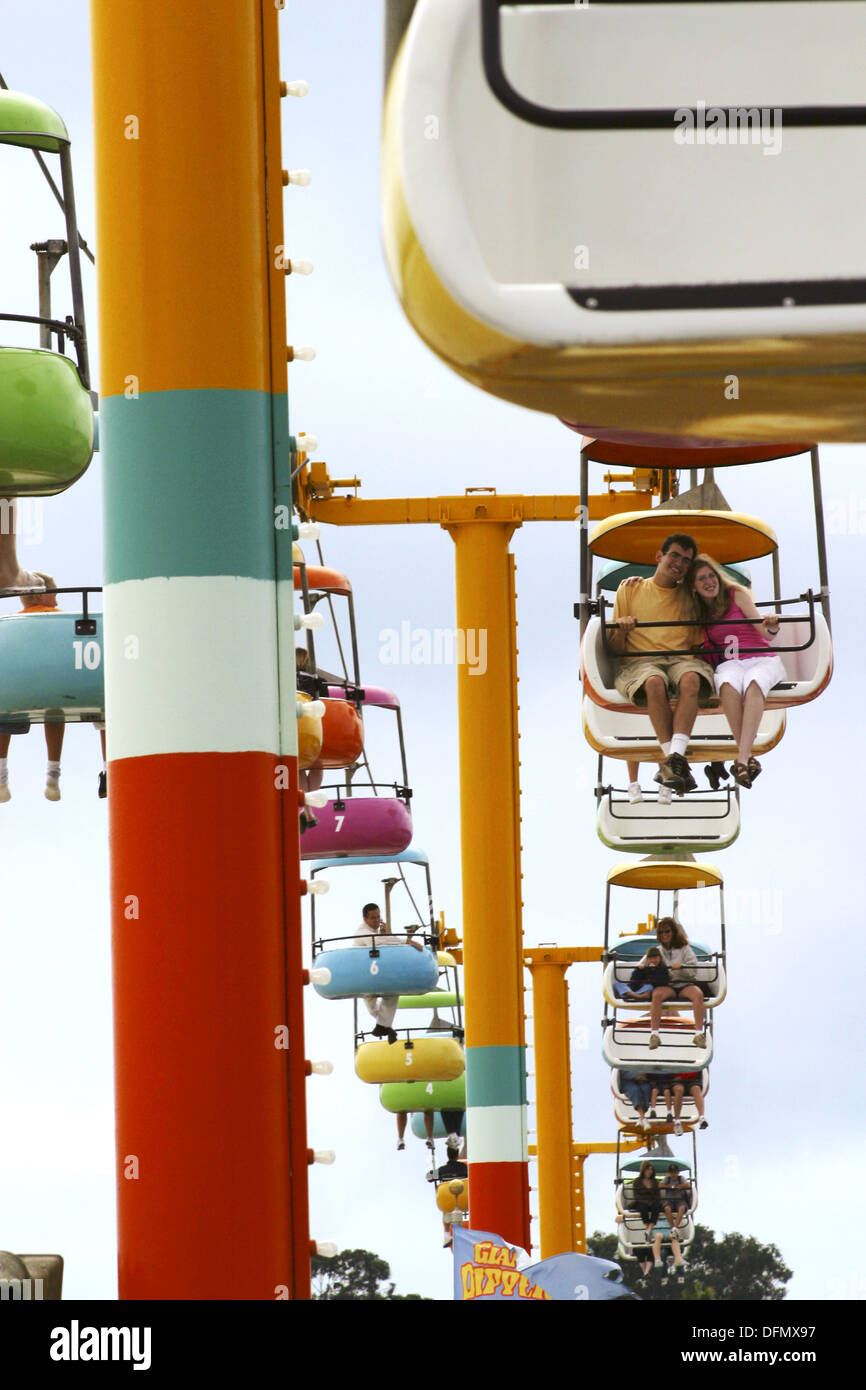 People riding colorful gondola cars above the santa cruz boardwalk in