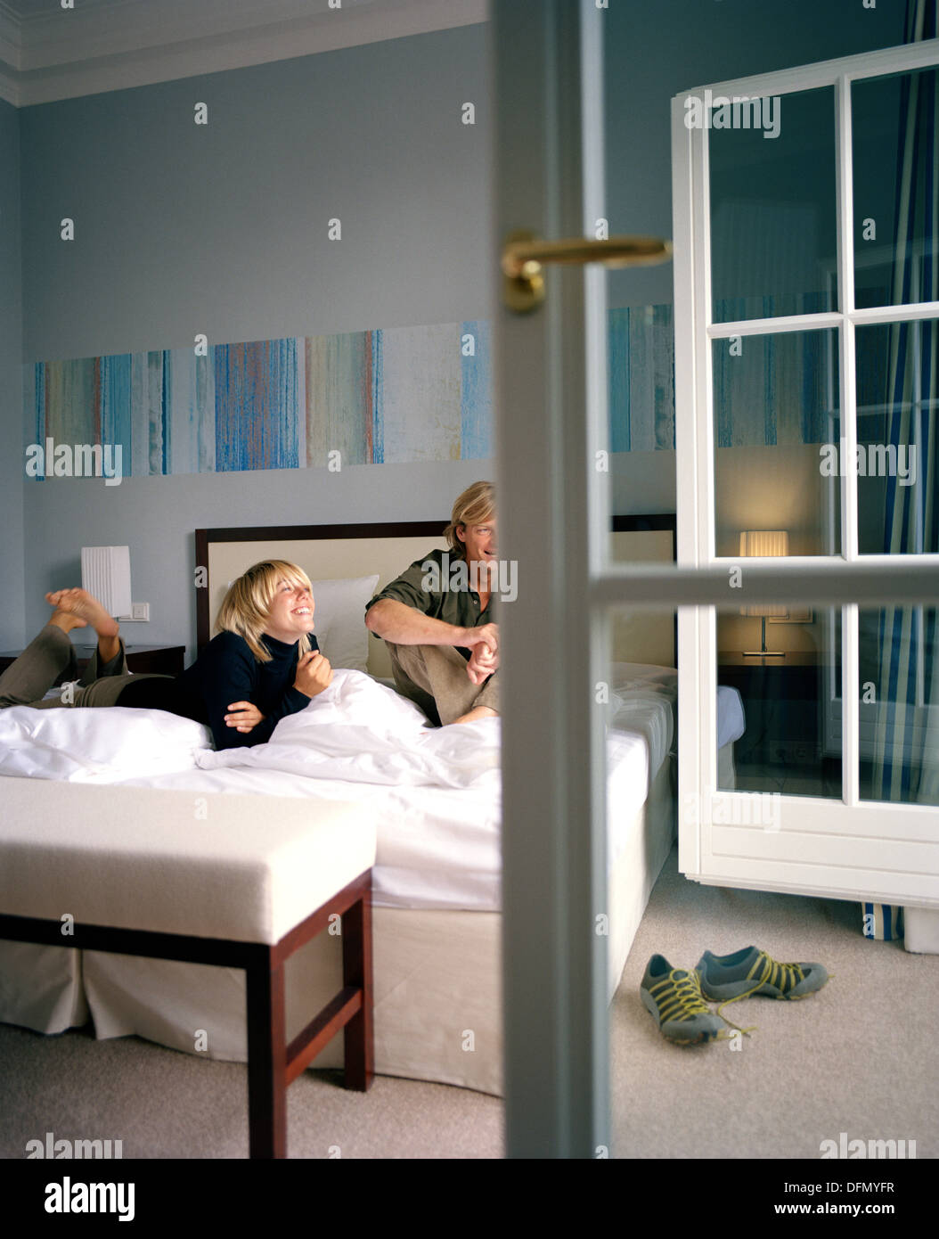 Couple on a double bed in a hotel room, spa resort, Travemuende, Luebeck, Schleswig-Holstein, Germany Stock Photo