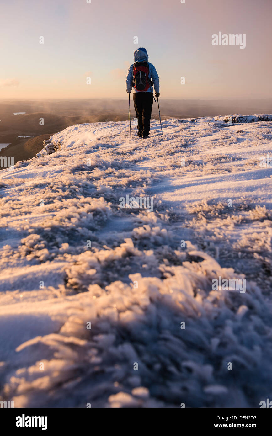 Female hiker at sunrise on winter summit of Pen Y Fan, Brecon Beacons national park, Wales Stock Photo