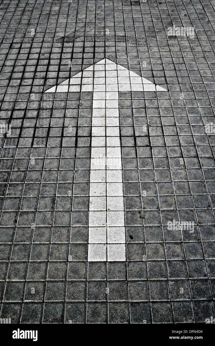 White arrow on pavement. Business vision, obligation, right way or the only way concept. Stock Photo