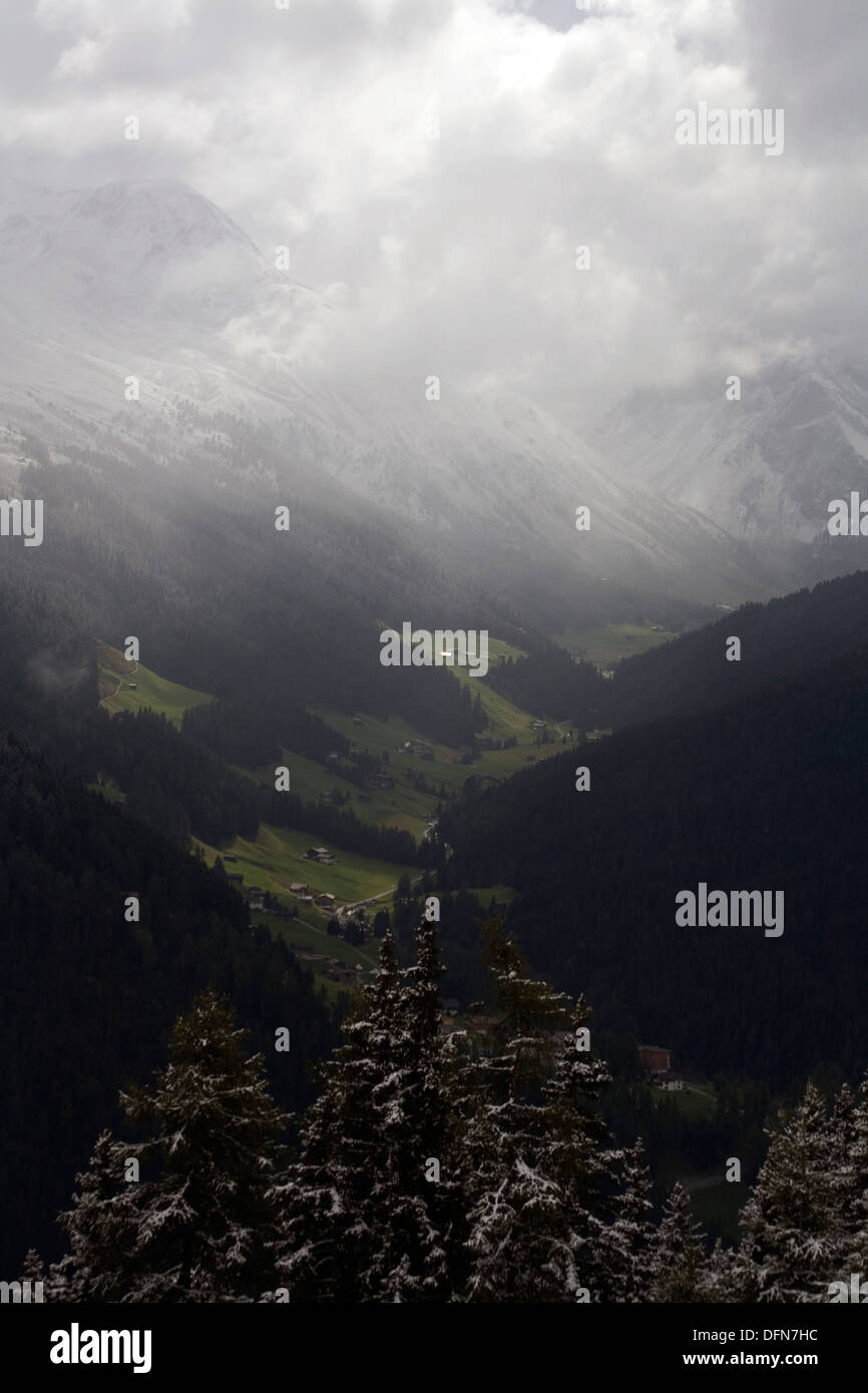 Shafts of sunlight and storm clouds passing over The Sertig Tal of The Landwasser Valley Davos Graubunden Switzerland Stock Photo