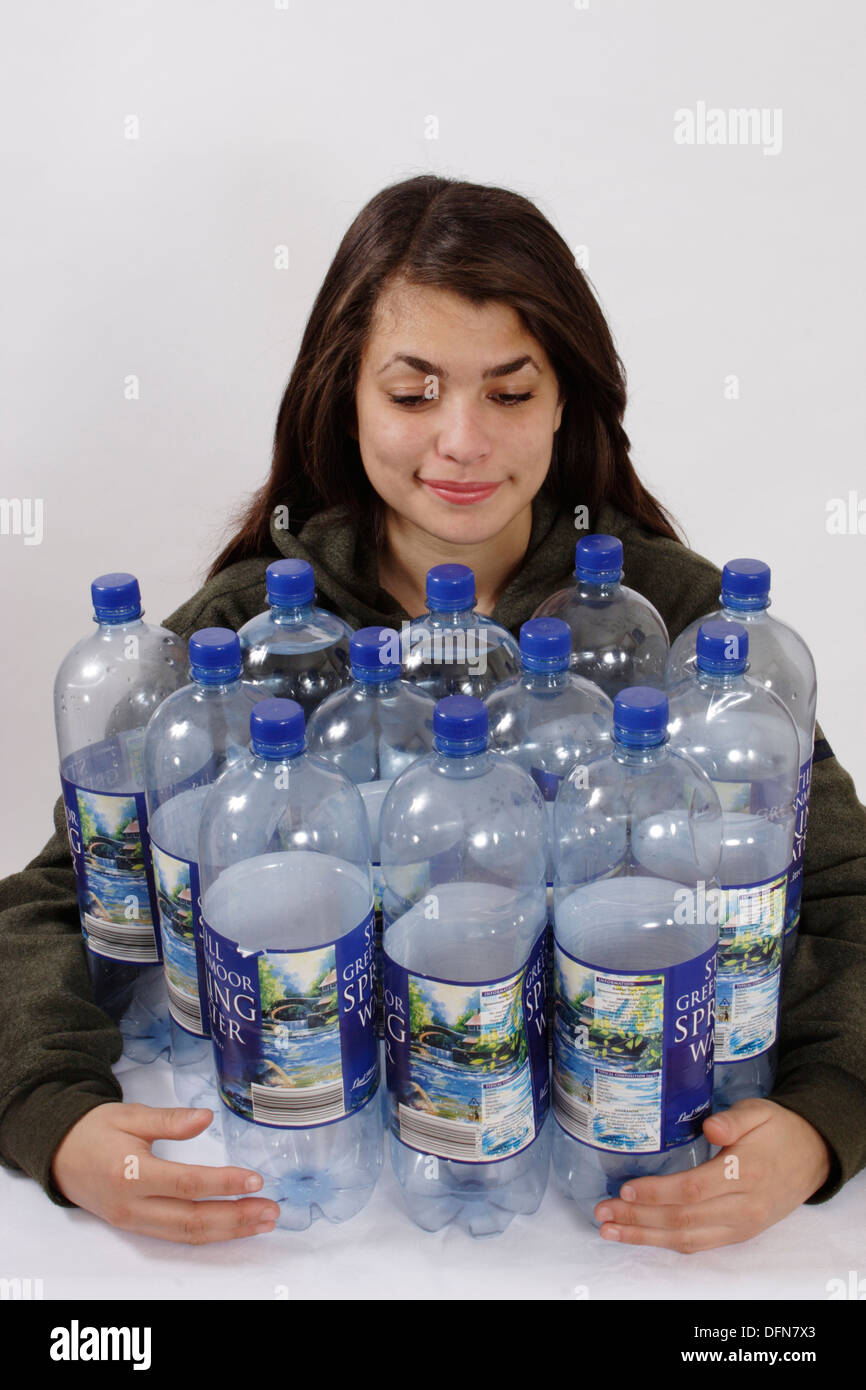 teenage girl posing with 12 plastic bottles to illustrate the recycling