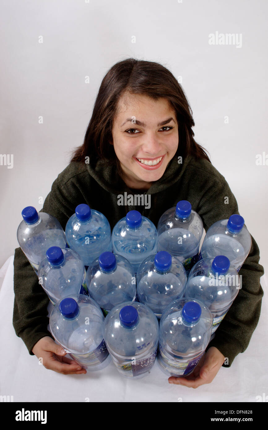 teenage girl posing with 12 plastic bottles to illustrate the recycling