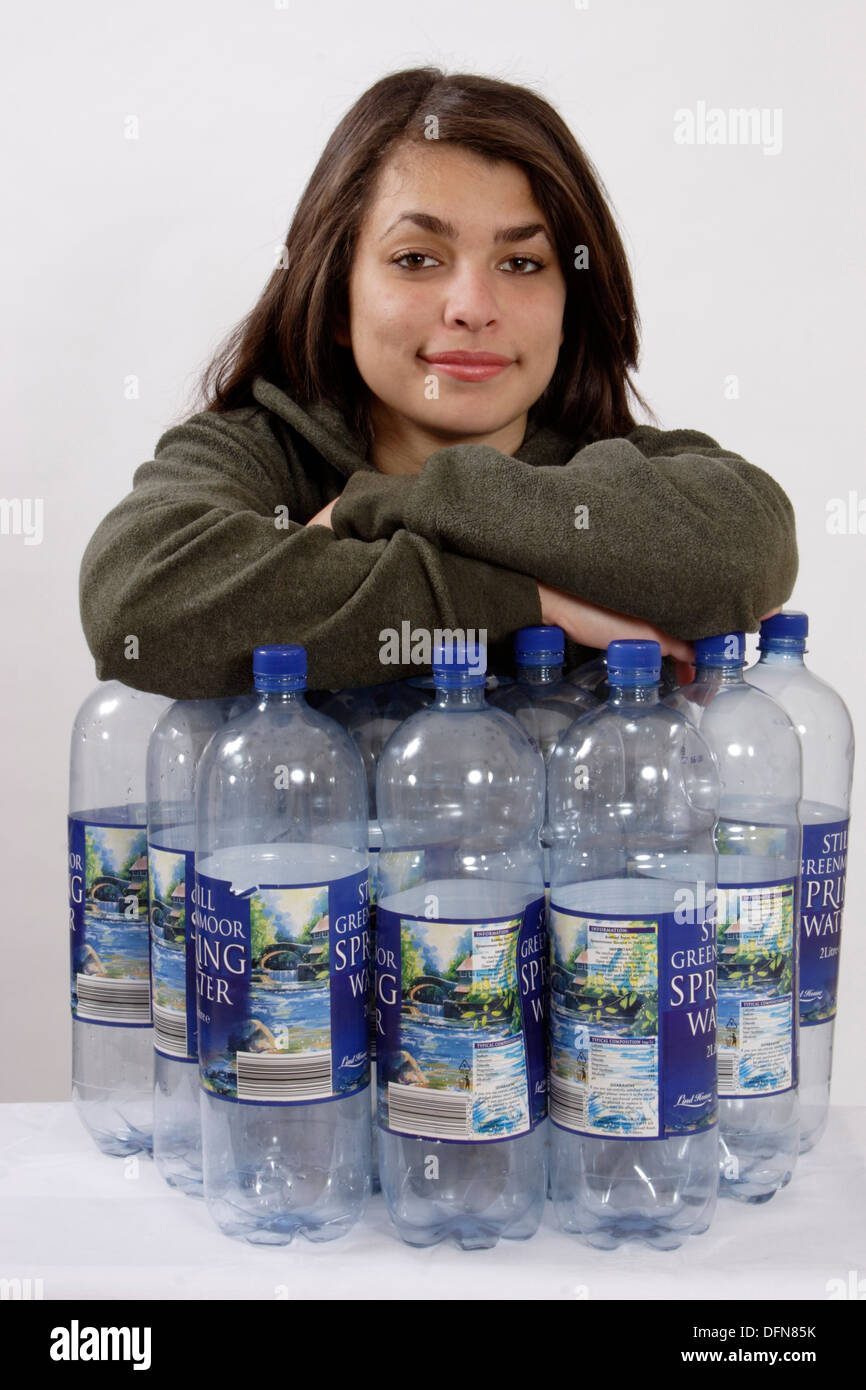 teenage girl posing with 12 plastic bottles to illustrate the recycling