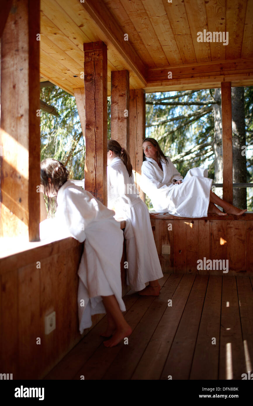 Mother and daughters wearing bathrobes on balcony of a nature hotel, Am Hochpillberg, Schwaz, Tyrol, Austria Stock Photo
