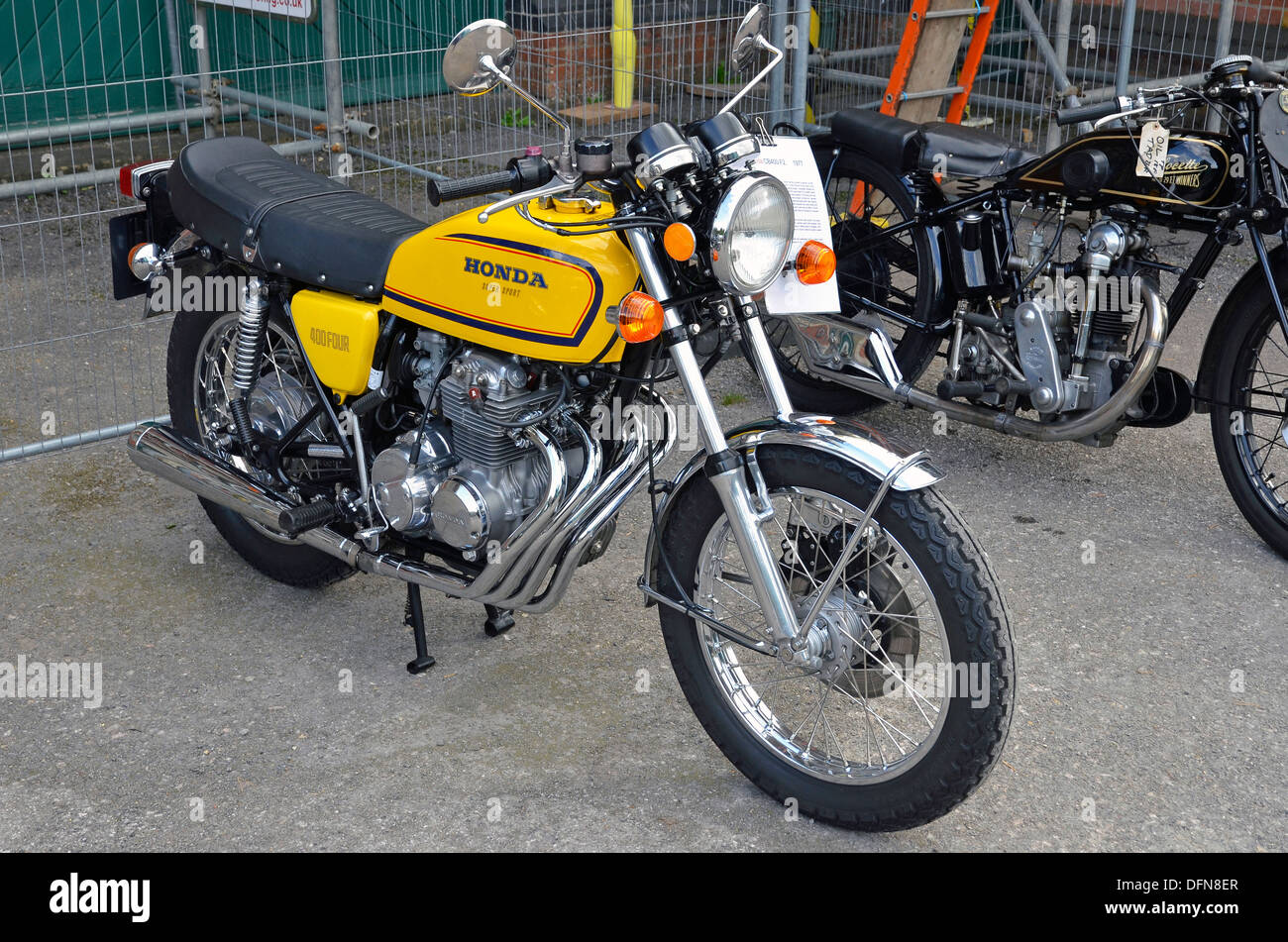 Well restored Honda CB400F motorcycle from 1977 with 1930's Velocette in the background. Stock Photo